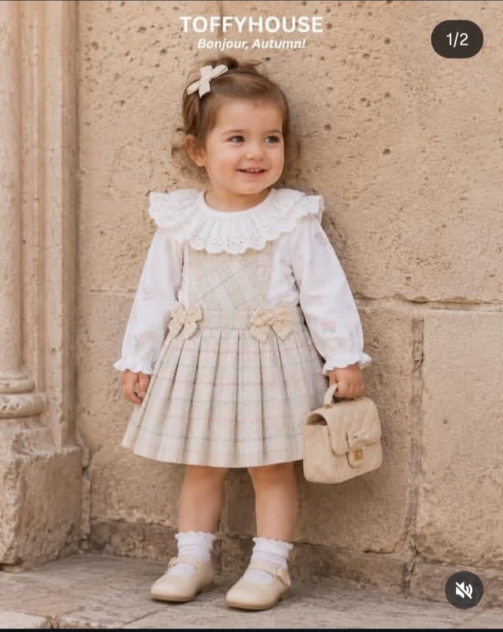 Toddler girl wearing a Toffy House autumn outfit with pleated skirt and lace collar